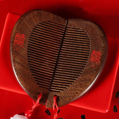 A pair of wooden combs with the Chinese character "喜" (happiness) and a heart shape